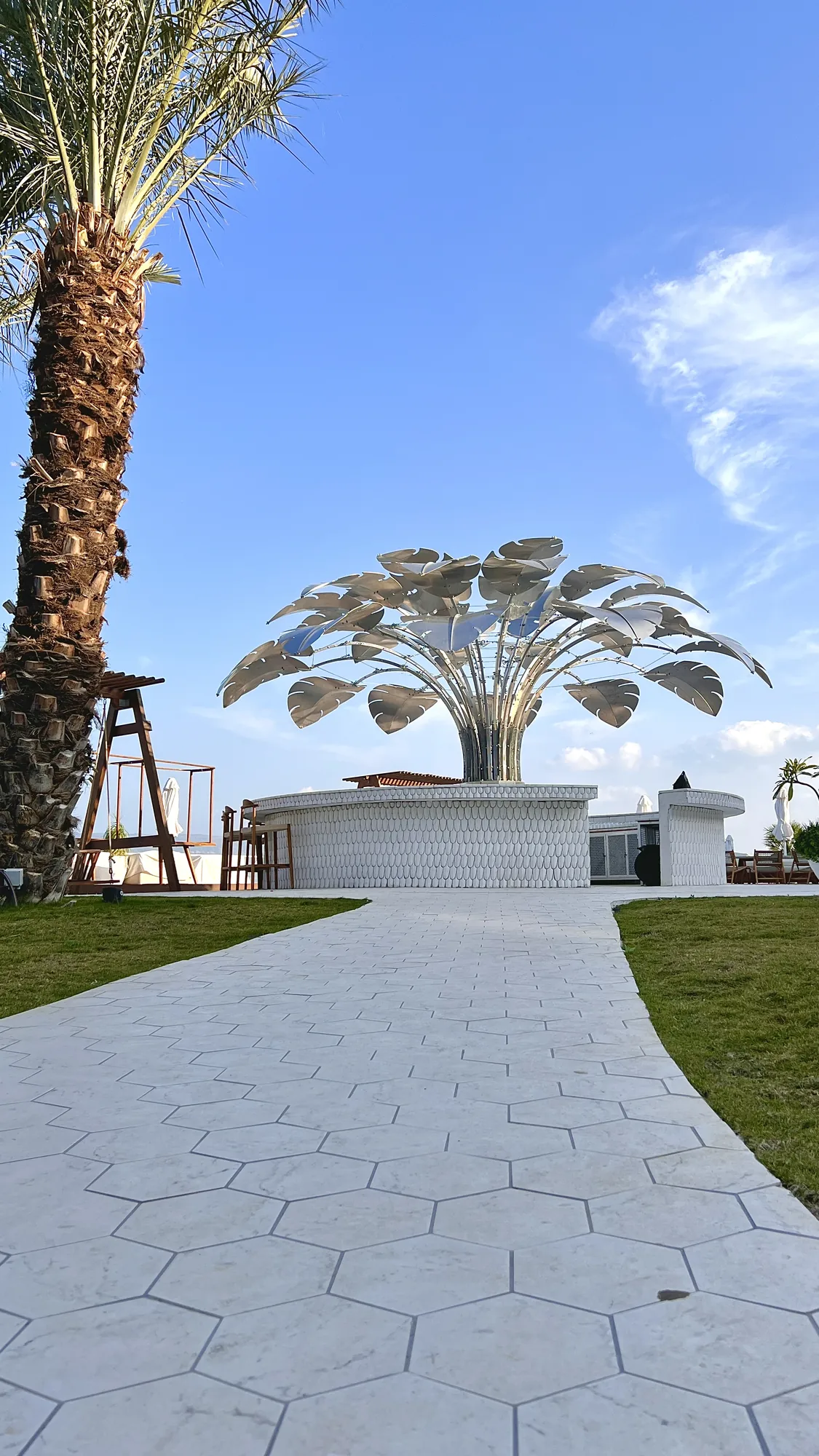 Bird of Paradise — A paradise bird grown from metal — a crown of silver monstera leaves eight metres across.
